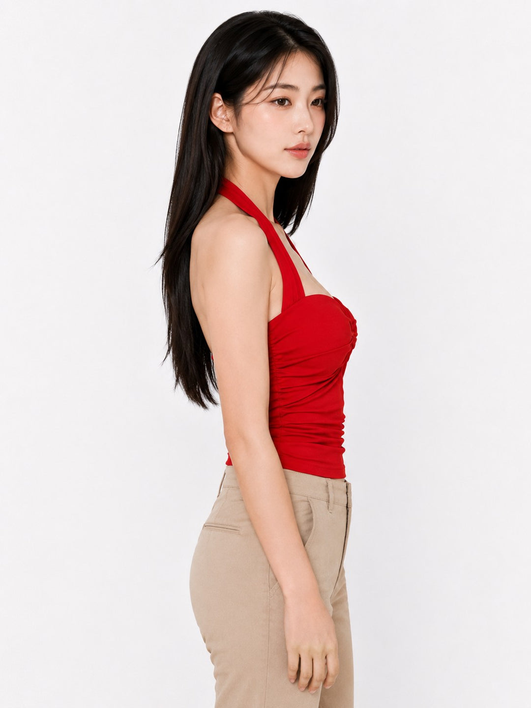 Woman wearing a red halter top and beige pants on a white background