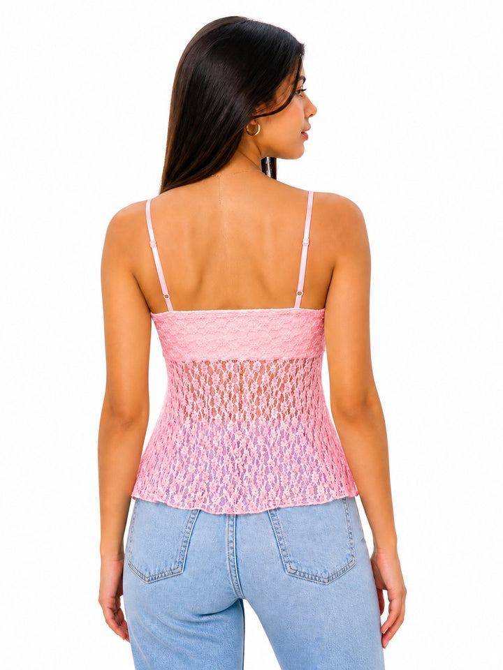 Woman wearing a pink lace top and light blue jeans on a white background