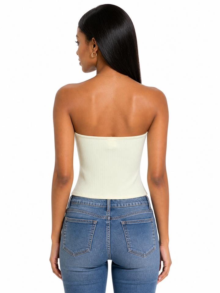 Woman wearing a strapless top and blue jeans on a white background