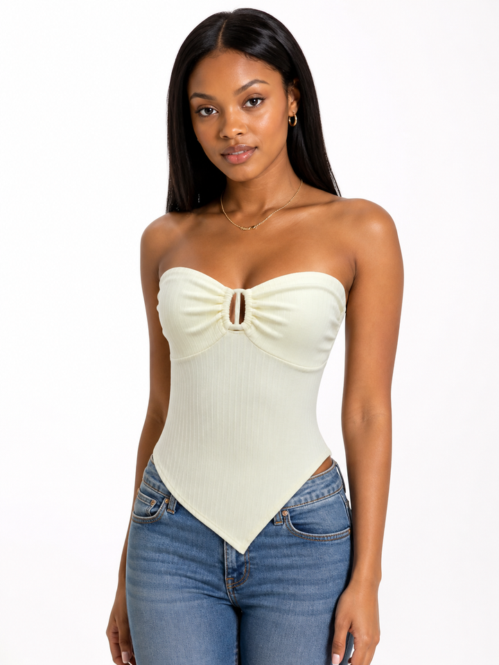 Woman wearing a cream strapless top and blue jeans on a white background
