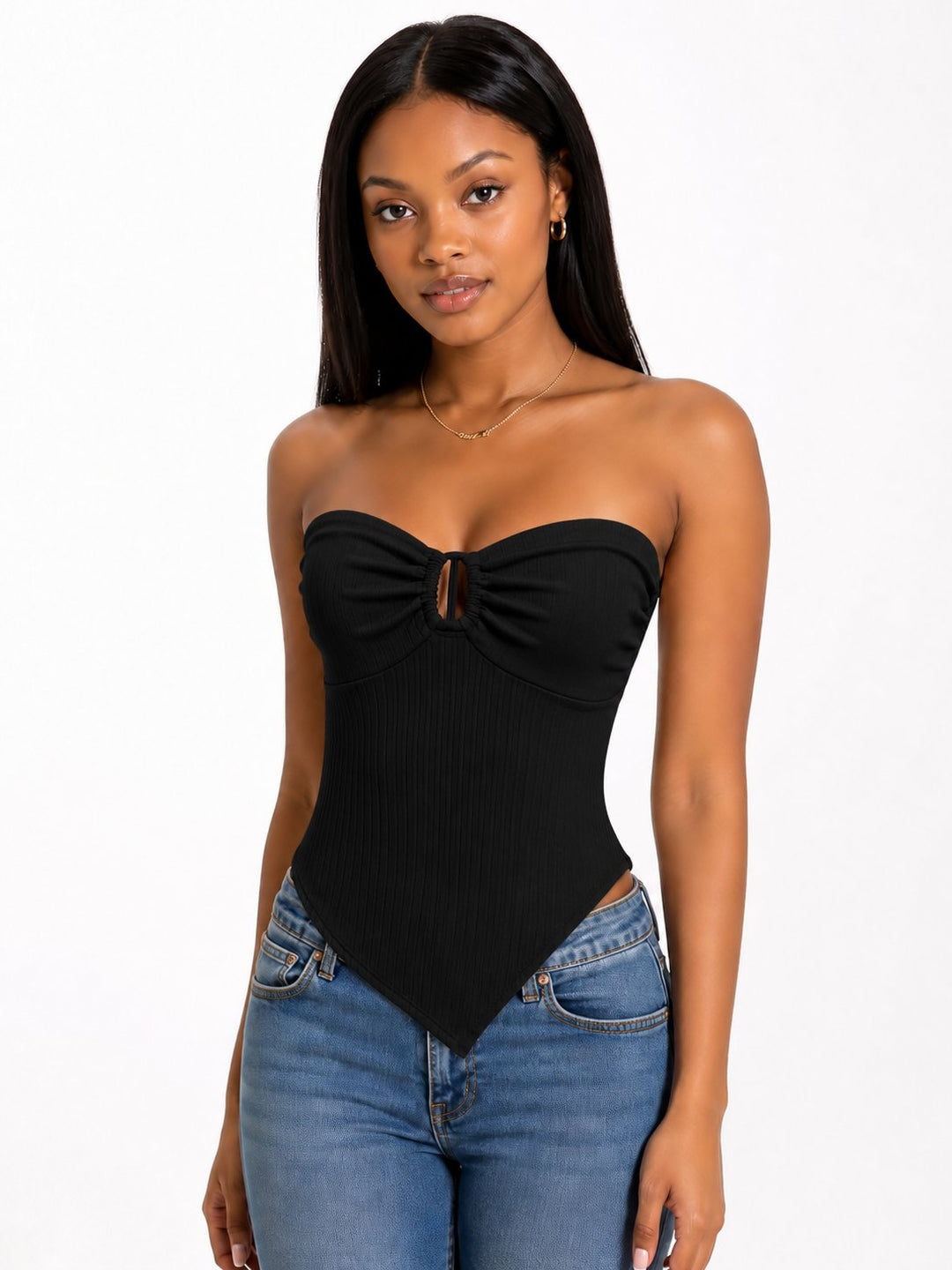 Woman wearing a black strapless top and blue jeans on a white background
