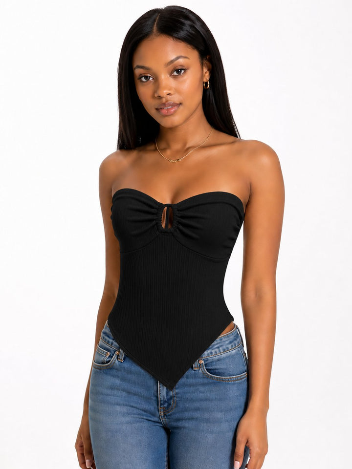 Woman wearing a black strapless top and blue jeans on a white background