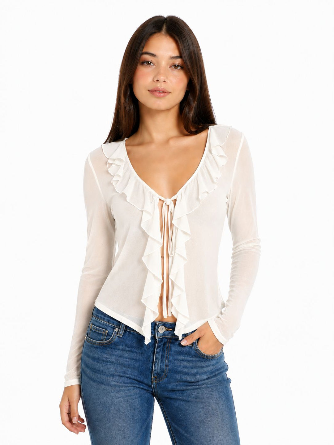 Woman wearing a white blouse with ruffles and blue jeans on a white background