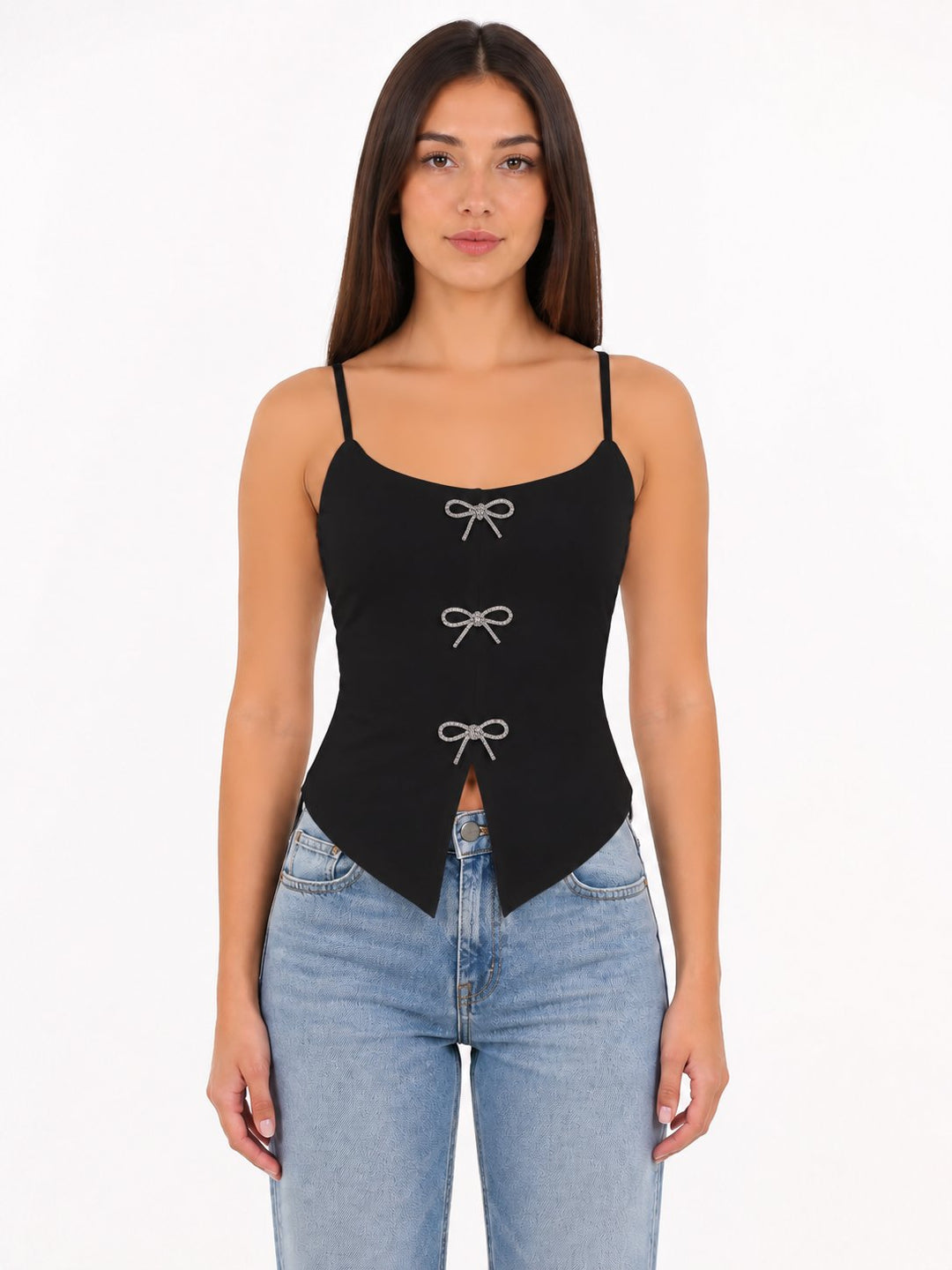 Woman wearing a black tank top with bow details and blue jeans on a white background