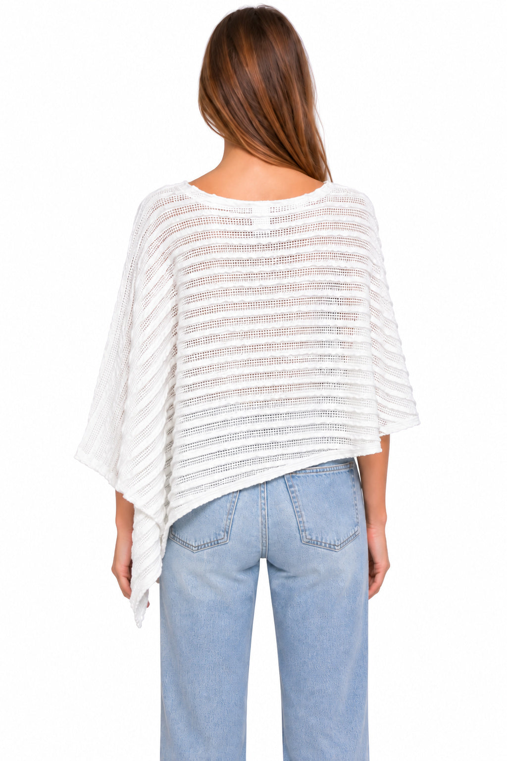A woman viewed from the back wearing a loose white textured top with wide draped sleeves and light blue jeans, against a plain white studio background.