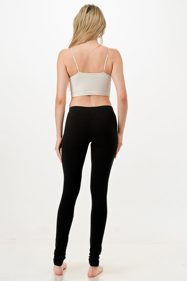 Person wearing a white sports bra and black leggings on a white background