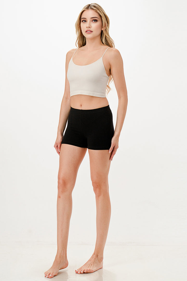 Woman wearing a white tank top and black shorts on a white background