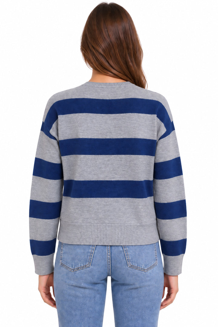 A woman viewed from the back wearing a gray and navy blue horizontally striped knit sweater with light blue jeans, set against a plain white background.