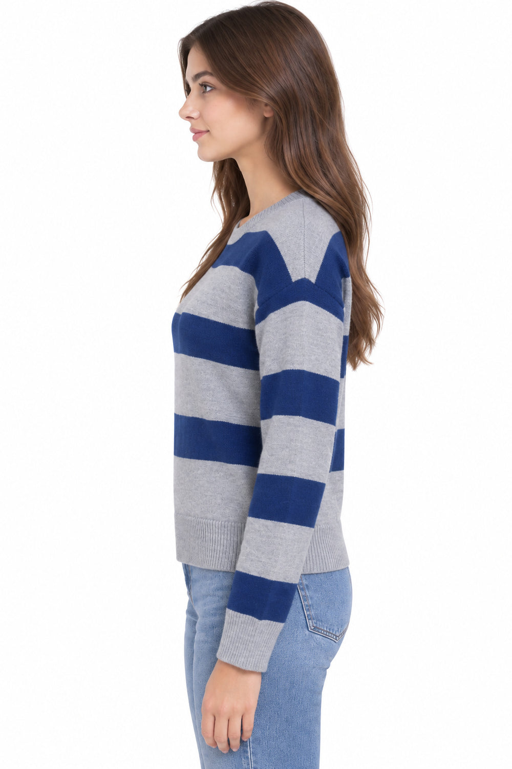 A woman shown in side profile wearing a gray and navy blue striped knit sweater with light blue jeans, set against a plain white background.