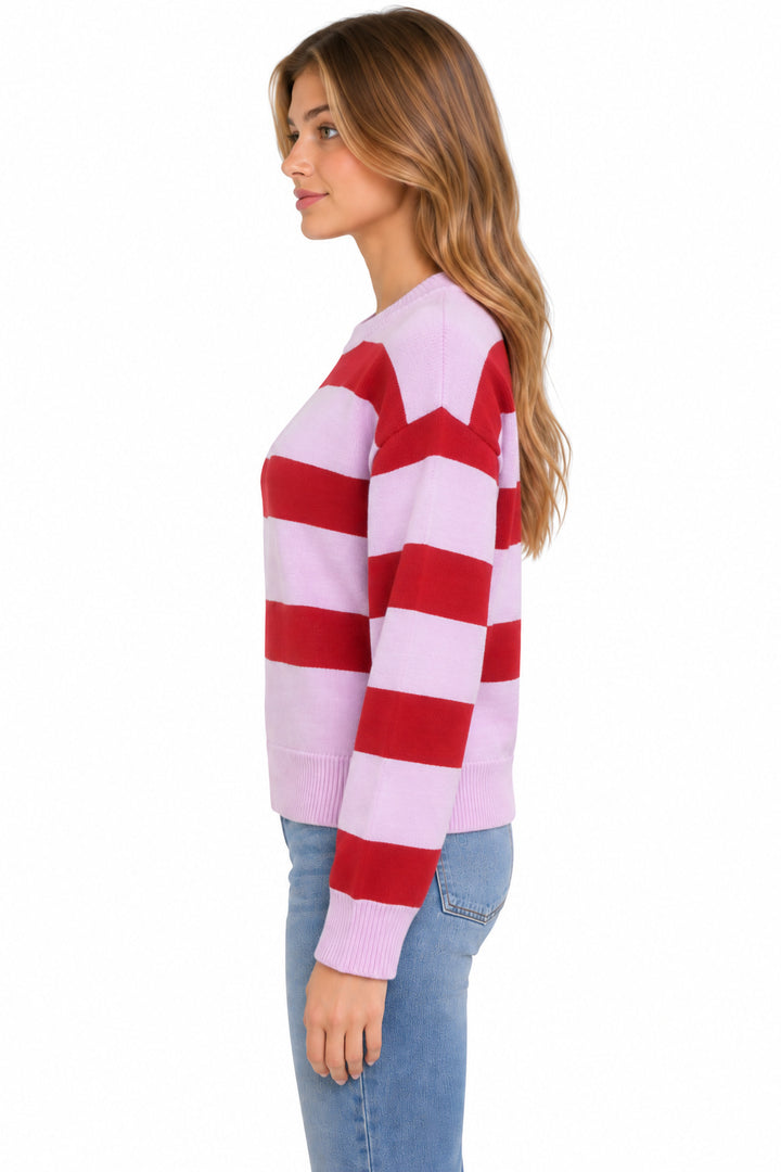 A woman shown in side profile wearing a light pink and red horizontally striped knit sweater with light blue jeans, against a plain white background.